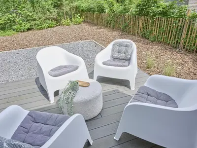 a patio with white chairs and a couch and a cactus at De Eekhoorn in Zutendaal