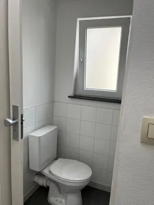 a bathroom with a white toilet and a window at Superbe studio calme et cosy in Saint-Léonard