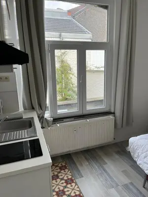 a kitchen with two large windows in a room at Superbe studio calme et cosy in Saint-Léonard