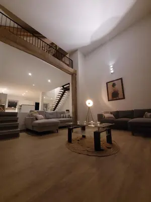 a living room with a couch and a table at La grange aux anneaux in Beaurieux