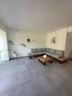 a living room with two couches and a table at La grange aux anneaux in Beaurieux