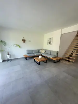 a living room with two couches and a staircase at La grange aux anneaux in Beaurieux