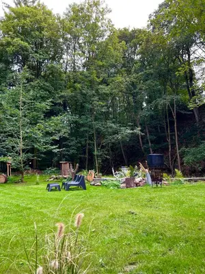 a field of grass with trees and picnic tables at Petit Château in Eupen