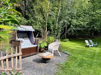 a garden with a bench and a table and chairs at Petit Château in Eupen