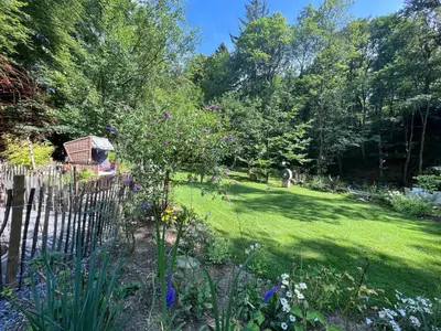 a garden with a wooden fence and flowers at Petit Château in Eupen