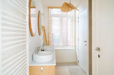 a bathroom with two sinks and a window at Sweet Coffee Stay in Hasselt