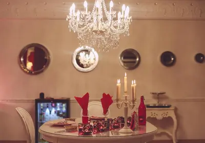 a dining room with a chandelier and a table with candles at Studio Le Baiser d'Angeli in Ensival