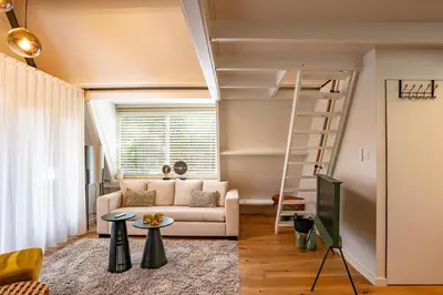 a living room with a ladder and a couch at Boshuisje Rekem - Ignis in Lanaken
