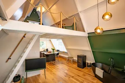 a room with green and white ceilings and a dining room at Boshuisje Rekem - Ignis in Lanaken