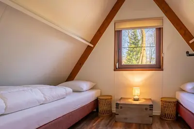 a room with two beds and a window at Boshuisje Rekem - Lotus in Lanaken