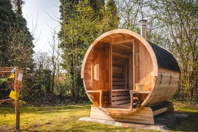 a small wooden hobbit house in a field at Boshuisje Rekem - Lotus in Lanaken