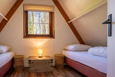 two beds in a room with a window at Boshuisje Rekem - Lotus in Lanaken