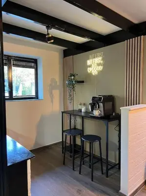 a kitchen with a counter and stools in a room at Etwee Vakantiehuis in Lanaken