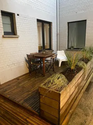 a wooden deck with a table and chairs on it at Loft St Remacle in Liège