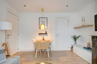 a living room with a table and a chair at - Le Cocoune - Cosy & Cute Flat in Liège
