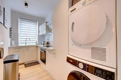 a kitchen with a washer and dryer at - Le Cocoune - Cosy & Cute Flat in Liège