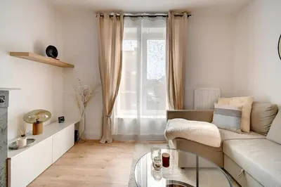 a living room with a couch and a glass table at - Le Cocoune - Cosy & Cute Flat in Liège