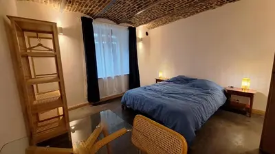 a bedroom with a bed and a glass table at Bed and breakfast Le fourchu fossé in Liège