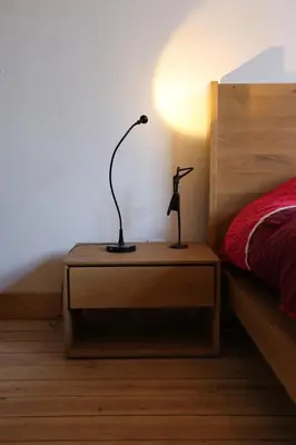a lamp on a night stand next to a bed at Bed and breakfast Le fourchu fossé in Liège