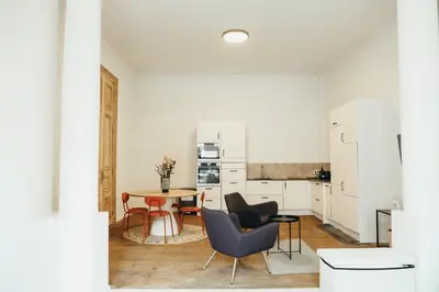 a kitchen and dining room with a table and chairs at La Terrasse des Guillemins by WelcHome in Liège