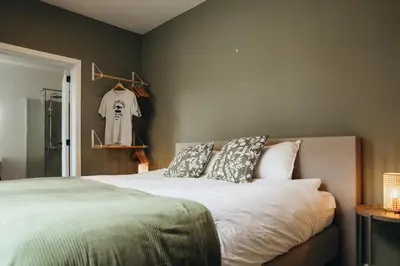 a bedroom with a bed with pillows and a closet at La Terrasse des Guillemins by WelcHome in Liège