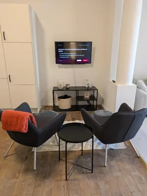 a living room with two chairs and a table at La Terrasse des Guillemins by WelcHome in Liège