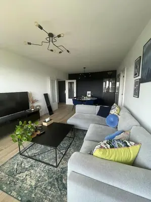 a living room with a couch and a table at Appartement panoramique plein sud Liège in Liège
