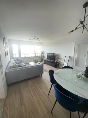 a living room with a couch and a table at Appartement panoramique plein sud Liège in Liège
