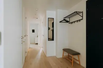 a hallway with a chair and a mirror on a wall at 2 bedroom apartment and private parking in Liège center in Liège