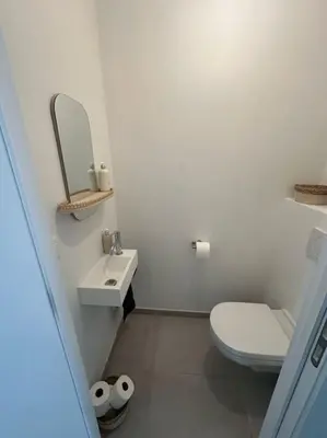 a white bathroom with a toilet and a sink at 2 bedroom apartment and private parking in Liège center in Liège