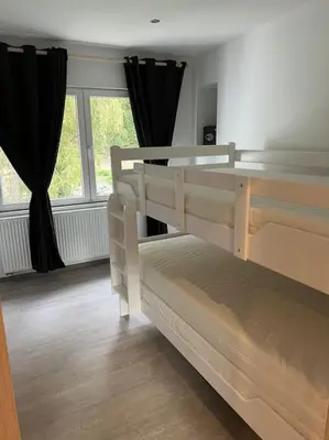 a bedroom with two bunk beds and a window at Riverside house in Trooz