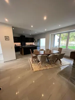 a living room with a dining room table and chairs at Riverside house in Trooz