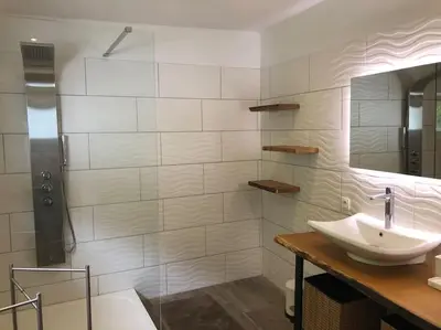 a white bathroom with a sink and a shower at Riverside house in Trooz