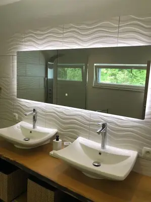 a bathroom with two sinks and a large mirror at Riverside house in Trooz