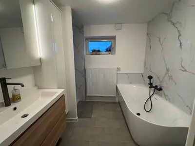 a white bathroom with a tub and a sink at Vakantiewoning Gruitrode in Oudsbergen