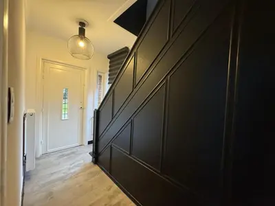 a hallway with a large black door and a room with a door at Vakantiewoning Gruitrode in Oudsbergen