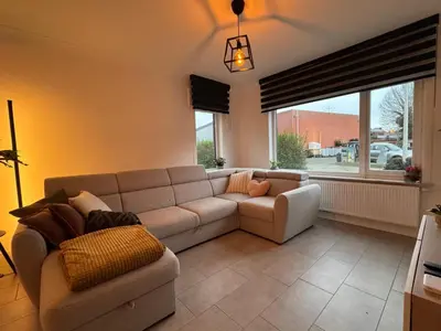 a living room with a couch and a large window at Vakantiewoning Gruitrode in Oudsbergen