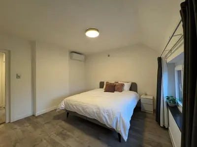 a bedroom with a bed with white sheets at Vakantiewoning Gruitrode in Oudsbergen