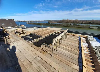 a wooden deck with benches on top of the water at Waterside Zen - Maastricht in Visé