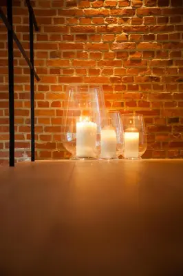 two candles in front of a brick wall at O-Lit in Paal