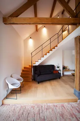 a living room with a black couch and stairs at O-Lit in Paal