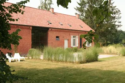 a red brick house with a white bench in front of it at O-Lit in Paal