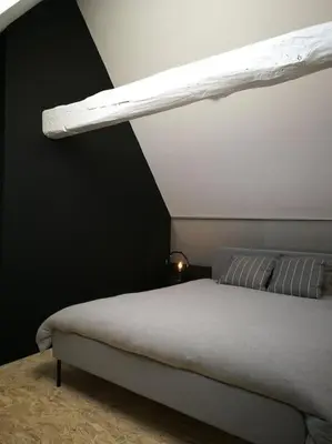 a bedroom with a bed with a light above it at Duplex in the historic heart of Liège - 3rd floor in Liège
