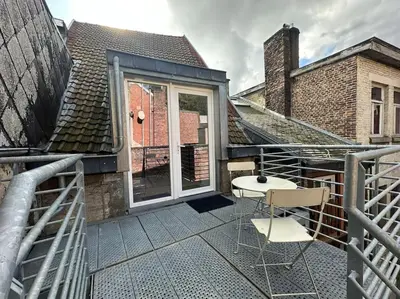 a balcony with two chairs on a building at Duplex in the historic heart of Liège - 3rd floor in Liège