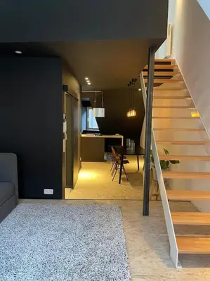 a staircase in a room with a couch and a table at Duplex in the historic heart of Liège - 3rd floor in Liège