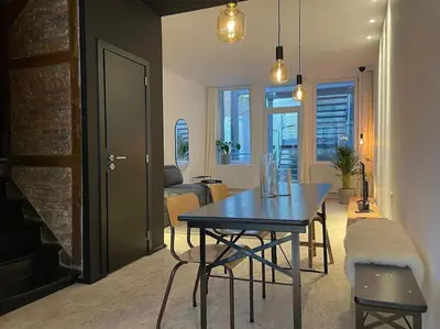a living room with a table and a dining room at 2 bedroom duplex in the historic heart of Liège in Liège