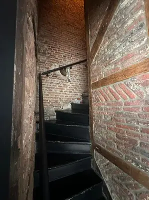 a stairway in a brick building with a brick wall at 2 bedroom duplex in the historic heart of Liège in Liège
