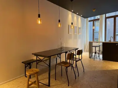 a dining room with a black table and chairs at 2 bedroom duplex in the historic heart of Liège in Liège