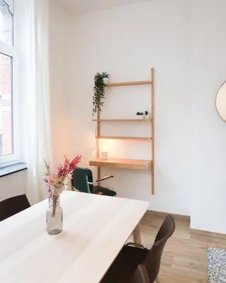 a white table with a vase of flowers on it at 1 bedroom apartment in Liège center - 1st floor in Liège