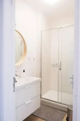 a white bathroom with a shower and a sink at 1 bedroom apartment in Liège center - 1st floor in Liège